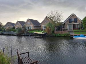 a row of houses on a river with a boat at Zoete Zee Huis in Medemblik