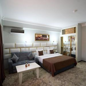 pokój hotelowy z łóżkiem i kanapą w obiekcie Bey Hotel Baku w mieście Baku
