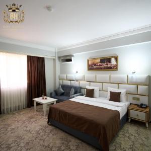 a hotel room with a large bed and a couch at Bey Hotel Baku in Baku