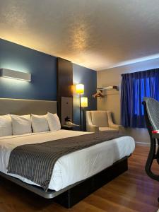 ein Hotelzimmer mit einem Bett und einem Stuhl in der Unterkunft Rodeway Inn in Emporia