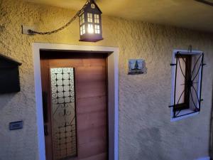 una puerta a una casa con una luz encima en In cima alla contrada en Pieve di Cadore