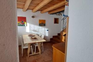 een kleine keuken met een tafel en een trap bij In cima alla contrada in Pieve di Cadore