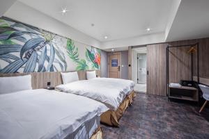 una habitación de hotel con 2 camas y un cuadro en la pared en 墨鐵會館 en Taichung