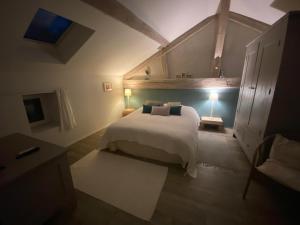 a bedroom with a large white bed in a room at la grange aux oiseaux in Arnaville
