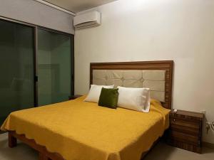una camera con letto giallo e 2 cuscini verdi di - Casa Blanca - a Ocotlán