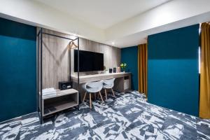 a hotel room with a bed and a television at 墨鐵會館 in Taichung