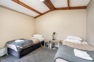 a room with two beds and a table in it at Home In Naseby in Naseby