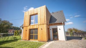 ein mit Holz verkleidetes Haus mit einer weißen Tür in der Unterkunft Öko-Neubau Ferienhaus - KOGELBUCH COMFORT in Nestelbach bei Graz
