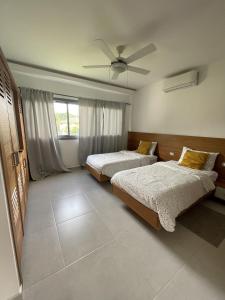 - une chambre avec 2 lits et un ventilateur de plafond dans l'établissement Los Peacocks - Premier Accommodations, à Las Terrenas