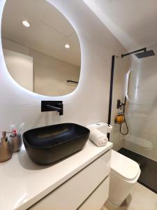 a bathroom with a black sink and a mirror at Nuevo Hola Madrid BIS in Madrid