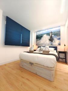 a bedroom with a bed with a large painting on the wall at Nuevo Hola Madrid BIS in Madrid