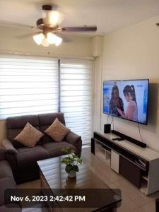 ein Wohnzimmer mit einem Sofa und einem Flachbild-TV in der Unterkunft The SPLENDOR comfortable living by Awsom Phil in Manila