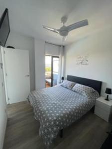 Schlafzimmer mit einem Bett und einem Deckenventilator in der Unterkunft Apartamento céntrico Playa de Aro con piscina. in Platja  d'Aro