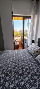 a bedroom with a bed and a large window at Apartamento céntrico Playa de Aro con piscina. in Platja  d'Aro