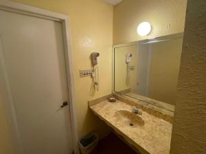 a bathroom with a sink with a mirror and a phone at Relax Inn Copperas Cove in Copperas Cove