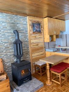 - une cuisine avec un poêle à bois et une table dans l'établissement Apartmani Košuta- Ljiljana Đokanović, à Jahorina