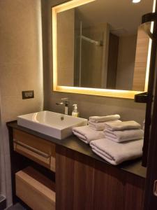 a bathroom with a sink and a mirror and towels at Woodside Kopaonik By Gogic in Kopaonik +2 photos