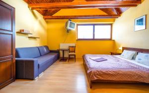 a room with a bed and a couch and a tv at Studio Troika in Pavčina Lehota