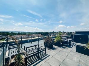 un balcón con bancos y palmeras en un edificio en Contemporary, stylish south coast home en Poole