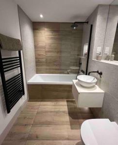 łazienka z wanną, toaletą i umywalką w obiekcie Contemporary, stylish south coast home w Poole