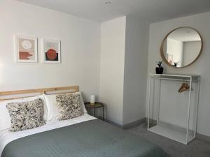 una camera con letto e specchio di Contemporary, stylish south coast home a Poole