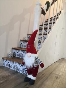 una muñeca Santa Claus parada al lado de un conjunto de escaleras en L 'ALBIZIA, en Chauvigny