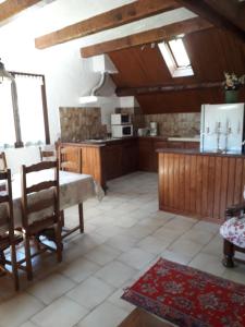 una cocina con armarios de madera, mesa y sillas en Appart chalet, en Saint-Martin-Vésubie