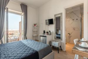 1 dormitorio con 1 cama, cocina y balcón en Capruzzi Guest House, en Bari