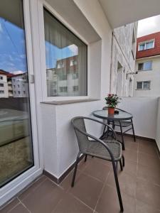 a patio with a table and chairs on a balcony at Apartament Gold Luxury in Tîrgu Ocna