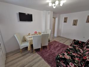 トゥルグ・オクナにあるApartament Gold Luxuryのテーブルと椅子とソファのあるダイニングルーム