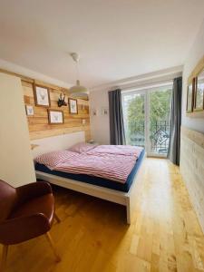 um quarto com uma cama, uma janela e uma cadeira em TOP 601 Lothringen house em Bad Gastein