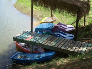 una mesa de madera y algunos barcos en el agua en Saichonview Riverkwai Resort, en Ban Dan Makham Tia