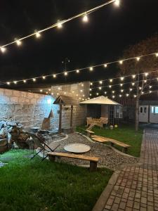 a patio at night with lights and picnic tables at Buna Guest House in Gyumri