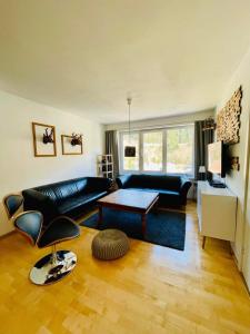 uma sala de estar com um sofá preto e uma mesa em TOP 601 Lothringen house em Bad Gastein