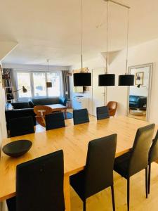 uma sala de estar com uma grande mesa de madeira e cadeiras em TOP 601 Lothringen house em Bad Gastein