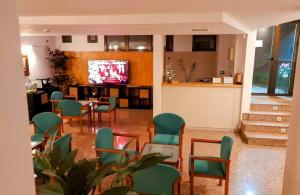 a waiting room with green chairs and a tv at Hotel Villa De Lerma in Lerma