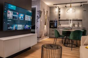 a kitchen and living room with a large screen tv at Ljubljana Urban Apartments in Ljubljana