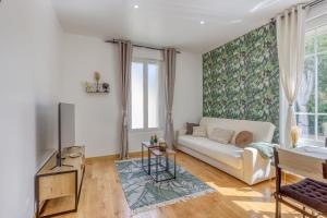 a living room with a couch and a tv at Joli Appartement de vacances in Écouen