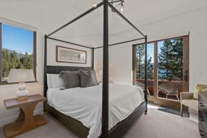 1 dormitorio con cama con dosel y balcón en Appreciate this exclusive private penthouse located on Lake Tahoe, en Crystal Bay