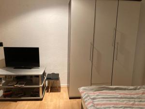 een woonkamer met een tv en een bed bij Schöne Dachgeschosswohnung in Essen