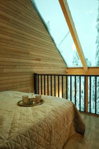 Bett in einem Zimmer mit einem großen Fenster in der Unterkunft Villa Auroras Karhu in Syöte