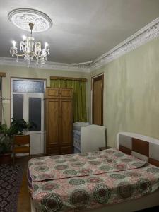 a bedroom with a bed and a chandelier at Friends House in Kutaisi