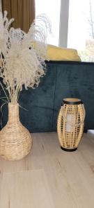 two wicker vases sitting on a wooden floor at apartament przy plaży w redłowie in Gdynia