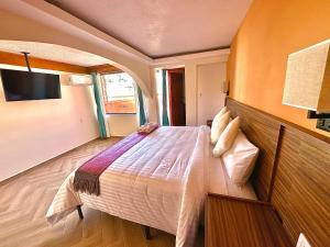 Un pat sau paturi într-o cameră la Suites del Jardín Principal