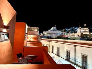 a view of a city at night from a balcony at Suites del Jardín Principal in Guanajuato