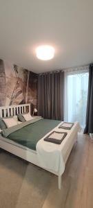 a bedroom with two beds and a large window at apartament przy plaży w redłowie in Gdynia