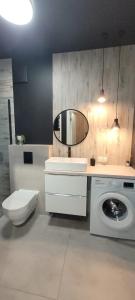 a bathroom with a washing machine and a mirror at apartament przy plaży w redłowie in Gdynia