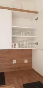 une cuisine avec un placard rempli de vaisselle dans l'établissement Apartament Nad Liwką, à Niechorze 11 autres photos