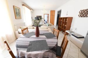 una sala de estar con una mesa con un jarrón. en NIKITA'S HOUSE - 3 min from racetrack - Free parking and Wifi - 7 guests, en Serres