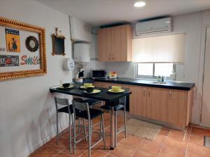 una cocina con mesa negra y sillas. en Casa Mencía, en Camponaraya